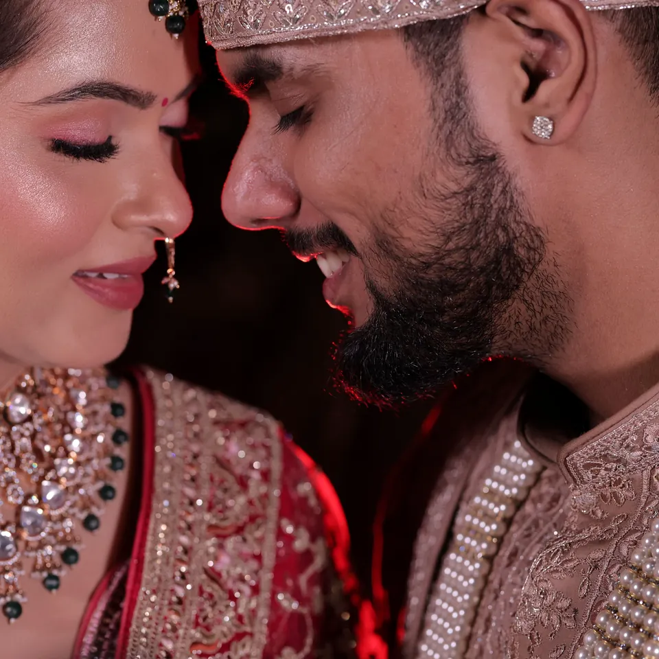 Joyful Indian bride and groom sharing a close wedding portrait