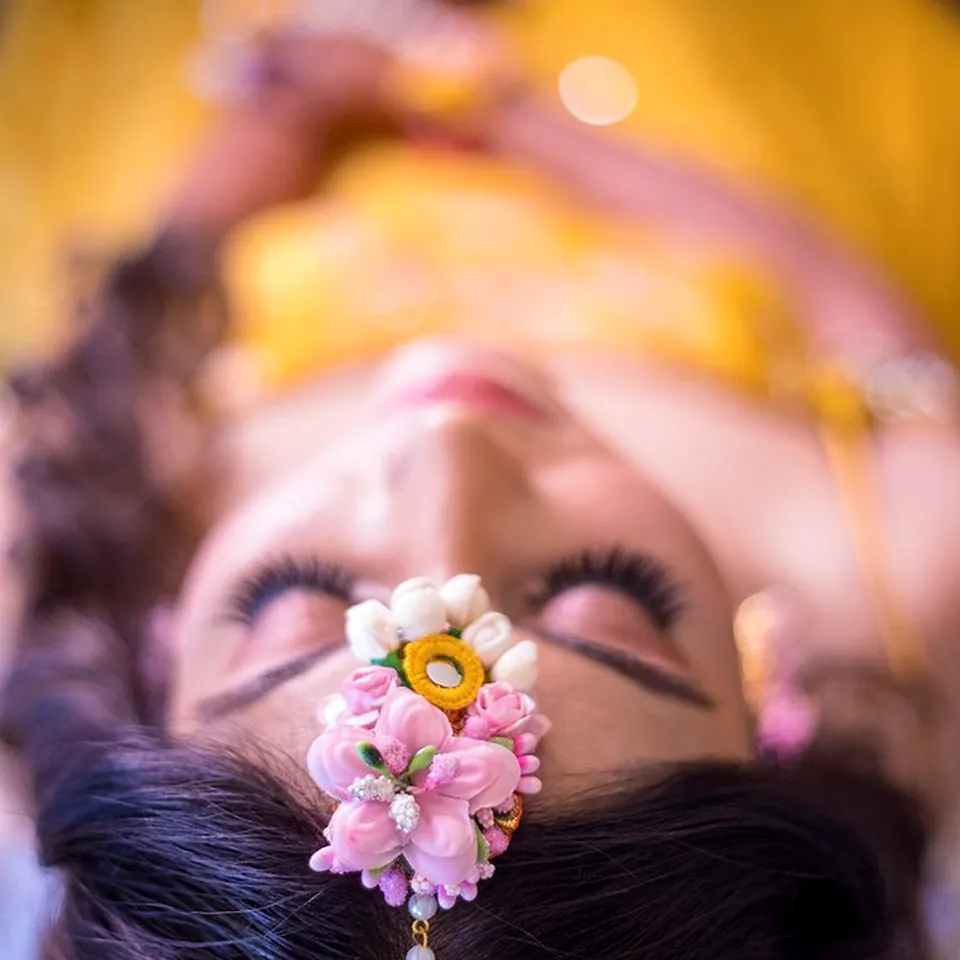 Creative close-up portrait of a bride wearing floral jewellery