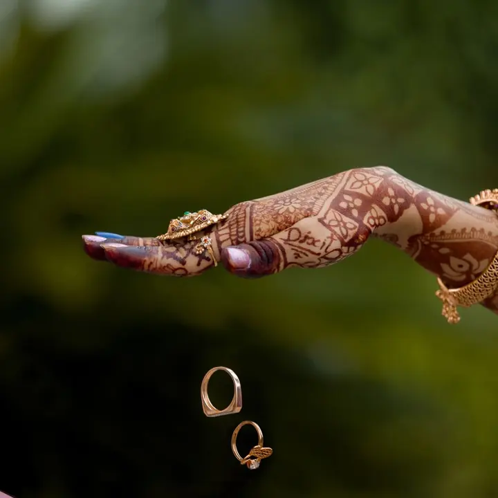 Wedding rings falling between the hands of a couple